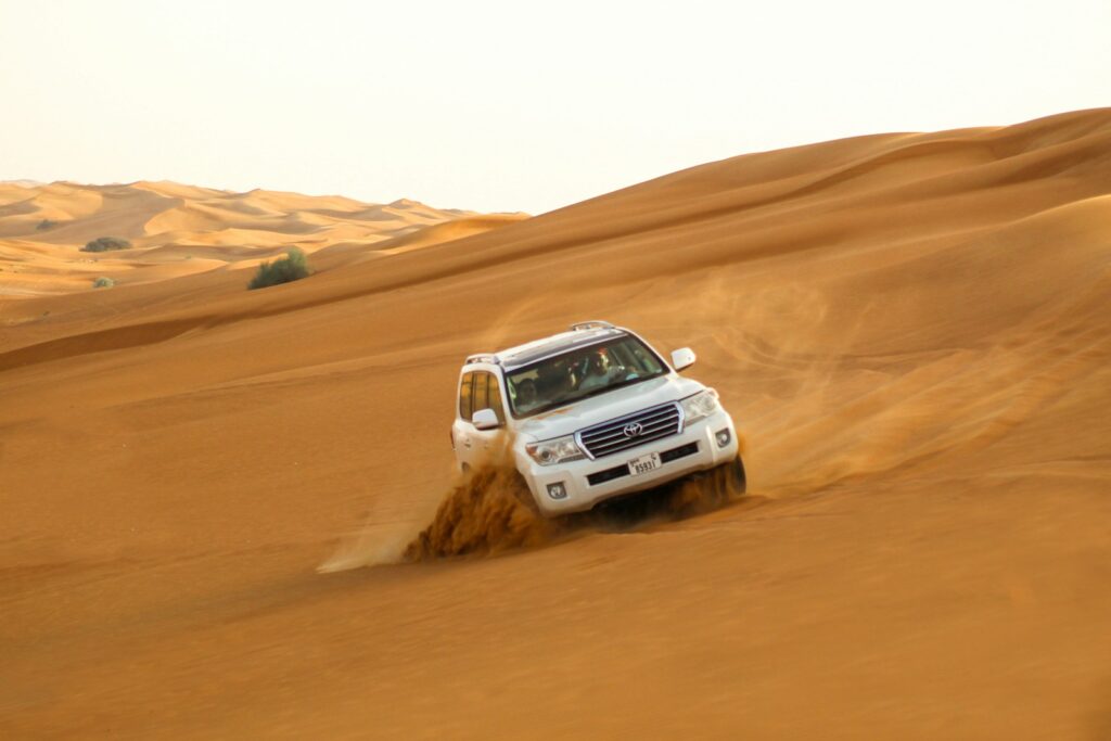 white suv on brown sand on Dubai Desert Safari